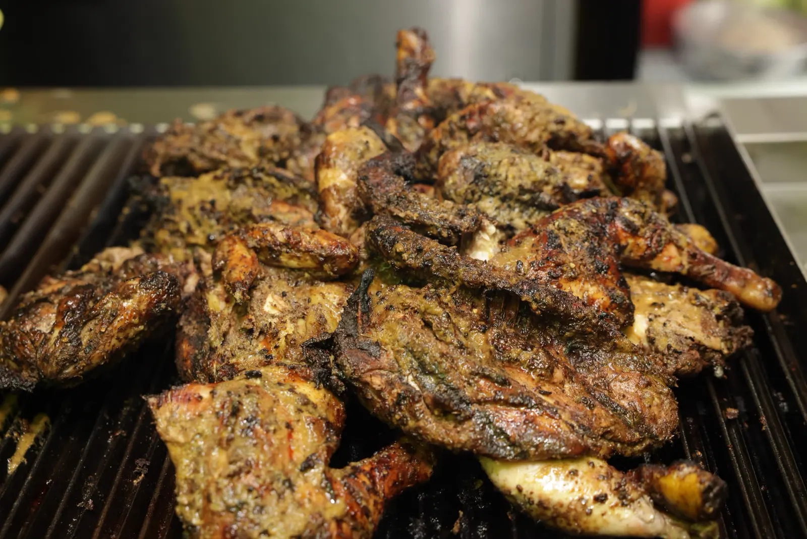 Jerk chicken piled high on the charcoal grill at Jerk Harbour