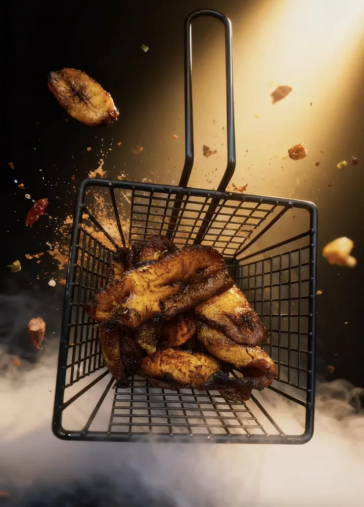 Fried plantain in a fryer basket, caramelised at the edges