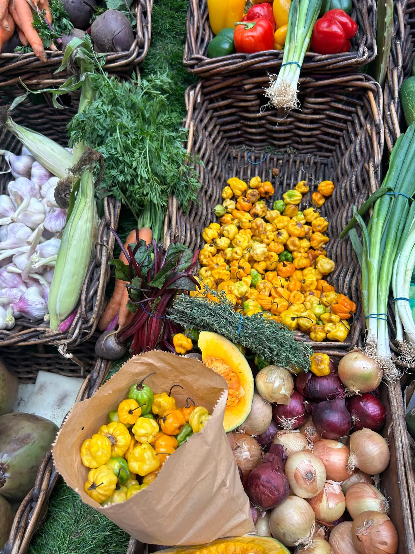 Baskets of scotch bonnet peppers, thyme, onions and fresh produce