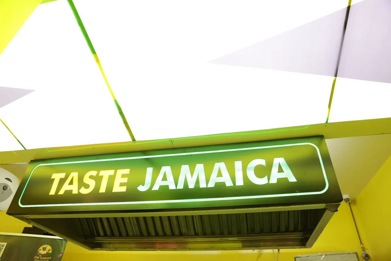 Neon Taste Jamaica sign above the Jerk Harbour kitchen